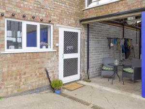 a patio with a white door and a table and chairs at The Milk Place in Harby