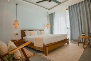 a bedroom with a bed and a large window at Montagne Boutique in Kampot