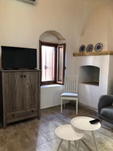 a living room with a tv and a couch and a table at Alicia's Traditional Home In Paradisi in Paradeísion