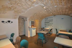 a restaurant with tables and chairs and a stone wall at Saint Georges Lafayette in Paris