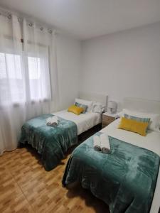 ein Schlafzimmer mit 2 Betten und Handtüchern darauf in der Unterkunft La casita de Meiro in Bueu