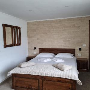 a bedroom with a bed with two pillows on it at Pensiunea casa Rareș in Curtea de Argeş +10 photos