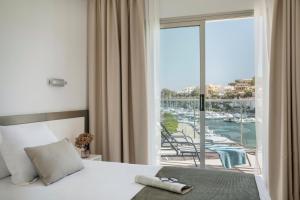 a bedroom with a bed and a view of a marina at Porto Drach Aparthotel & Suites in Porto Cristo