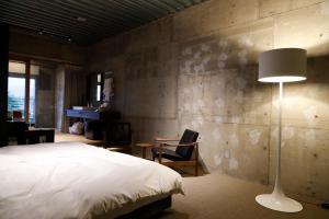 松本市にある松本十帖のベッドルーム(ベッド1台、ランプ、デスク付)