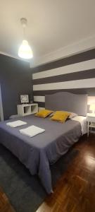 a bedroom with a large bed with yellow pillows at Ria do Sal in Aveiro