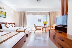 um quarto de hotel com duas camas e uma televisão de ecrã plano em Paradise Hotel em Da Nang
