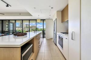a kitchen with white countertops and a view of a city at Darwin's Dazzler - Your Ultimate Waterfront Escape in Darwin
