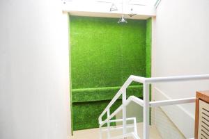 a green wall in a room with a staircase at 360° Guest House in Purwokerto