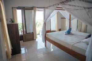 Un dormitorio con una cama con un pez azul. en Bukit Indah Homestay, en Amed