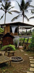 ein Gebäude mit einer Bank und Palmen im Hintergrund in der Unterkunft Ranggon d'tukad in Tabanan