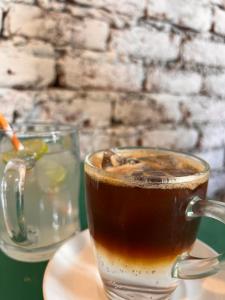 a cup of coffee sitting on a table with a drink at YOLO Backpackers MAX - Manali in Manāli