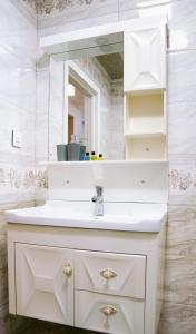 a bathroom with a white sink and a mirror at Престижная квартира Кара Караева in Baku