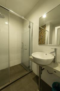 a bathroom with a sink and a glass shower at Waterfront Boutique Hotel in Port Dickson
