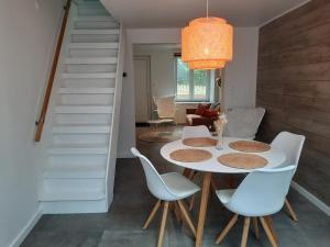 une salle à manger avec une table et des chaises blanches dans l'établissement Huisje op de Muur van Geraardsbergen, à Grammont