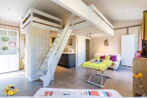 Pokój z łóżkiem na podwyższeniu i salonem w obiekcie Studio Plage Petit Piquey w mieście Lège-Cap-Ferret