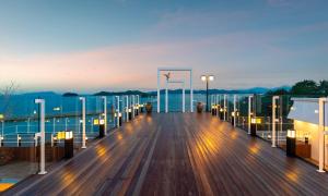 un paseo marítimo de madera en un crucero al atardecer en Owl Hotel, en Sacheon