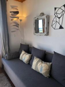 苏佩贝斯Lama-Gîte-des-Puys T3 Lamadalet, vue sud, terrasse, parking privé的客厅配有沙发、枕头和镜子