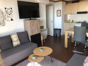 苏佩贝斯Lama-Gîte-des-Puys T3 Lamadalet, vue sud, terrasse, parking privé的带沙发和桌子的客厅和厨房
