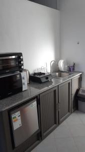 a kitchen with a counter top with a microwave and a sink at Residence Bethel in Rodrigues Island