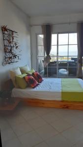 a bedroom with a large bed with a window at Residence Bethel in Rodrigues Island