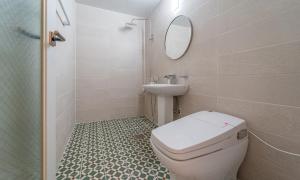 W łazience znajduje się toaleta, umywalka i lustro. w obiekcie Owl Hotel w Sacheon