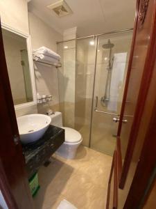 La salle de bains est pourvue d'un lavabo, de toilettes et d'une douche. dans l'établissement Khách Sạn A83Hotel, à Hanoï