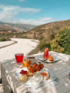a table with plates of food on a table with a view at Guesthouse Lord Byron in Tepelenë