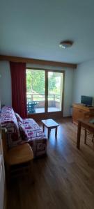 um quarto com uma cama, uma mesa e uma janela em Charmant appartement de 6 pers tout confort em Puy-Saint-Vincent