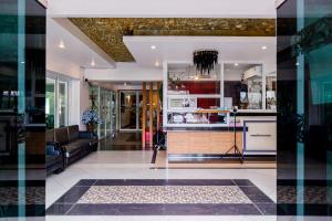 a living room with a couch and a kitchen at Latin Garden Hotel in Bangkok