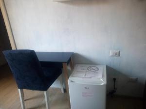 a blue chair and a desk and a washing machine at Monteceneri 9 B&b in Rho