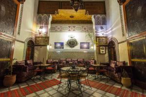 a room with tables and chairs in a building at Riad Meski in Fez