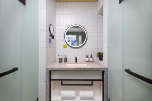 a bathroom with a sink and a mirror at lyf by Ascott Hongqiao Shanghai NECC in Shanghai