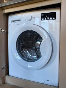 Un lave-linge blanc est installé dans une pièce. dans l'établissement Top Centre Zara Apartment, à Stara Zagora