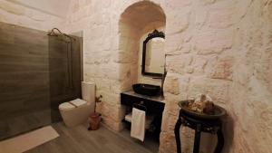 a bathroom with a sink and a toilet and a mirror at Aslanbey Konağı Butik Otel in Acırlı