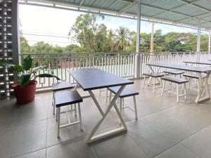 un ensemble de tables et de chaises sur un balcon dans l'établissement MJ Guest House Pusat Kota Malili Mitra RedDoorz, à Malili