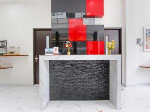 een open haard in een woonkamer met rode accenten bij Super OYO Capital O 91665 D'prof Exclusive Guesthouse in Semarang