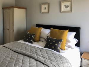 a bed with yellow and white pillows on it at The Old Dairy - Uk31253 in Middleton