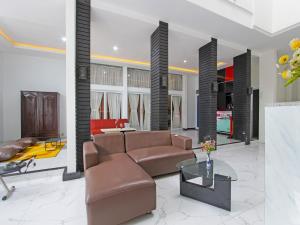 een woonkamer met een bank en een tafel bij Super OYO Capital O 91665 D'prof Exclusive Guesthouse in Semarang