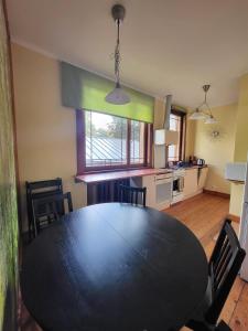 a dining room with a black table and a kitchen at 19 Jasminu street in Jūrmala