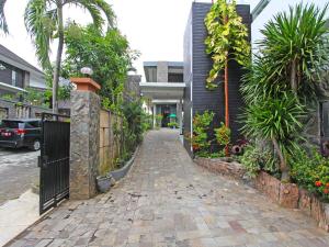 a walkway in front of a house with a fence at Super OYO Capital O 91665 D'prof Exclusive Guesthouse in Semarang