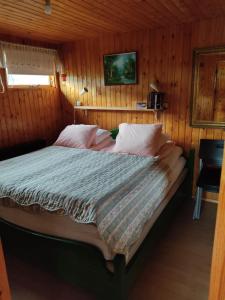 um quarto com uma cama num quarto de madeira em Litla Hlid em Goðdalir