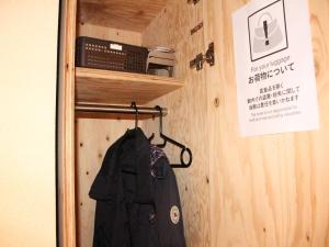 a jacket is hanging on a rack in a room at TRAVEL&BOOK HOTEL HULATONCABIN TAKAMATSU in Takamatsu