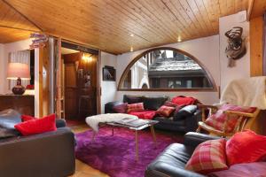 a living room with leather couches and a purple rug at Hôtel du Bourg in Valmorel