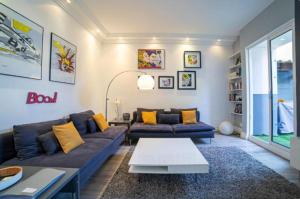 a living room with a blue couch and yellow pillows at Superbe 120m2 au Suquet - Property With Style in Cannes
