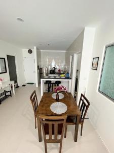 - une salle à manger avec une table et des chaises en bois dans l'établissement Aina Staycation, Metrocity, à Kuching