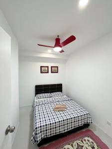 - une chambre avec un lit et un ventilateur de plafond dans l'établissement Aina Staycation, Metrocity, à Kuching