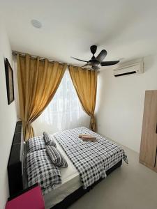 - une chambre avec un lit et un ventilateur de plafond dans l'établissement Aina Staycation, Metrocity, à Kuching