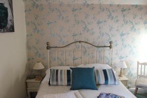 a bedroom with a bed with blue floral wallpaper at Ivy Bank Guest House - Room Only in Windermere