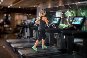 a woman running on a treadmill in a gym at Grand Hyatt Hong Kong in Hong Kong