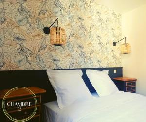 a bedroom with a bed with two lamps on the wall at L'authentique Martelaise PISCINE CHAUFFEE in Martel